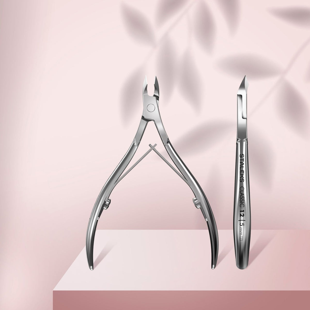 Staleks Classic 12 cuticle nippers with 5mm half jaw, full and side views on a pale pink background