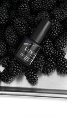 Akzentz Luxio Poison gel bottle among blackberries