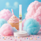 Cotton candy-flavored lip balm with cotton candy and cupcake in the background