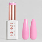 A bottle of BE-MI Beauty Box gel nail polish in a bright pink shade, shown next to two artificial nail tips painted in the same pink color, on a light gray background.