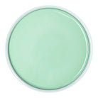 A round, top-down view of a glossy mint green cosmetic or paint container with a white rim on a solid white background.