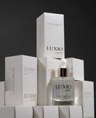 Luxio nail care products including a bottle and boxes on a black background