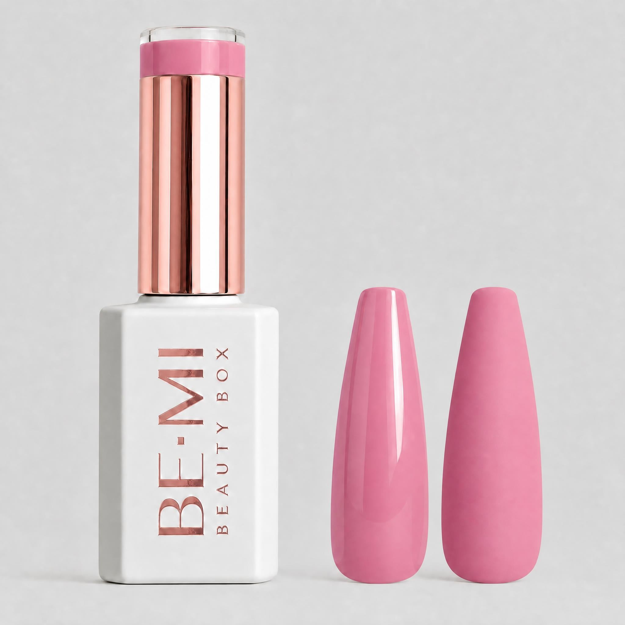 A bottle of BE-MI Beauty Box nail polish in a soft pink shade, shown next to two almond-shaped nail tips coated in the same pink polish, on a light gray background.
