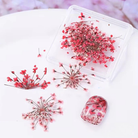 Transparent resin mold with pink dried flowers on a white surface