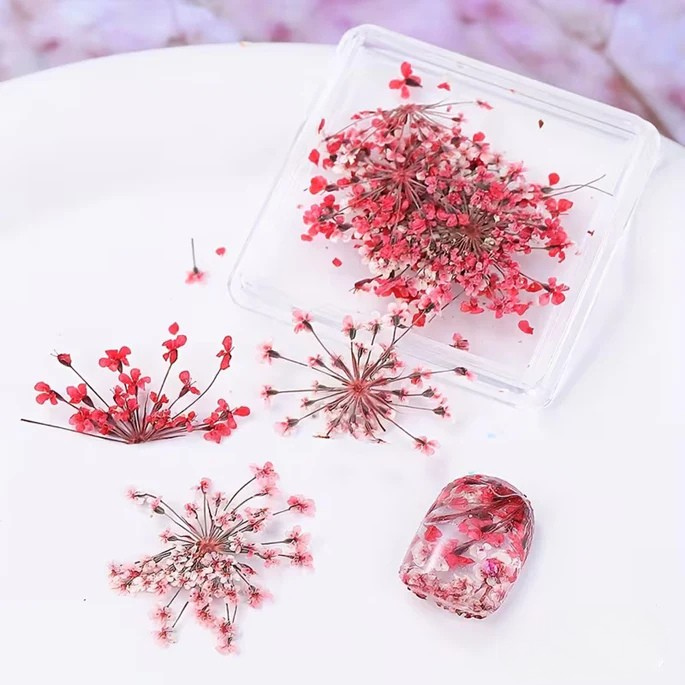 Transparent resin mold with pink dried flowers on a white surface