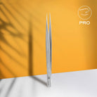Staleks straight eyelash tweezers displayed on an orange promotional graphic.